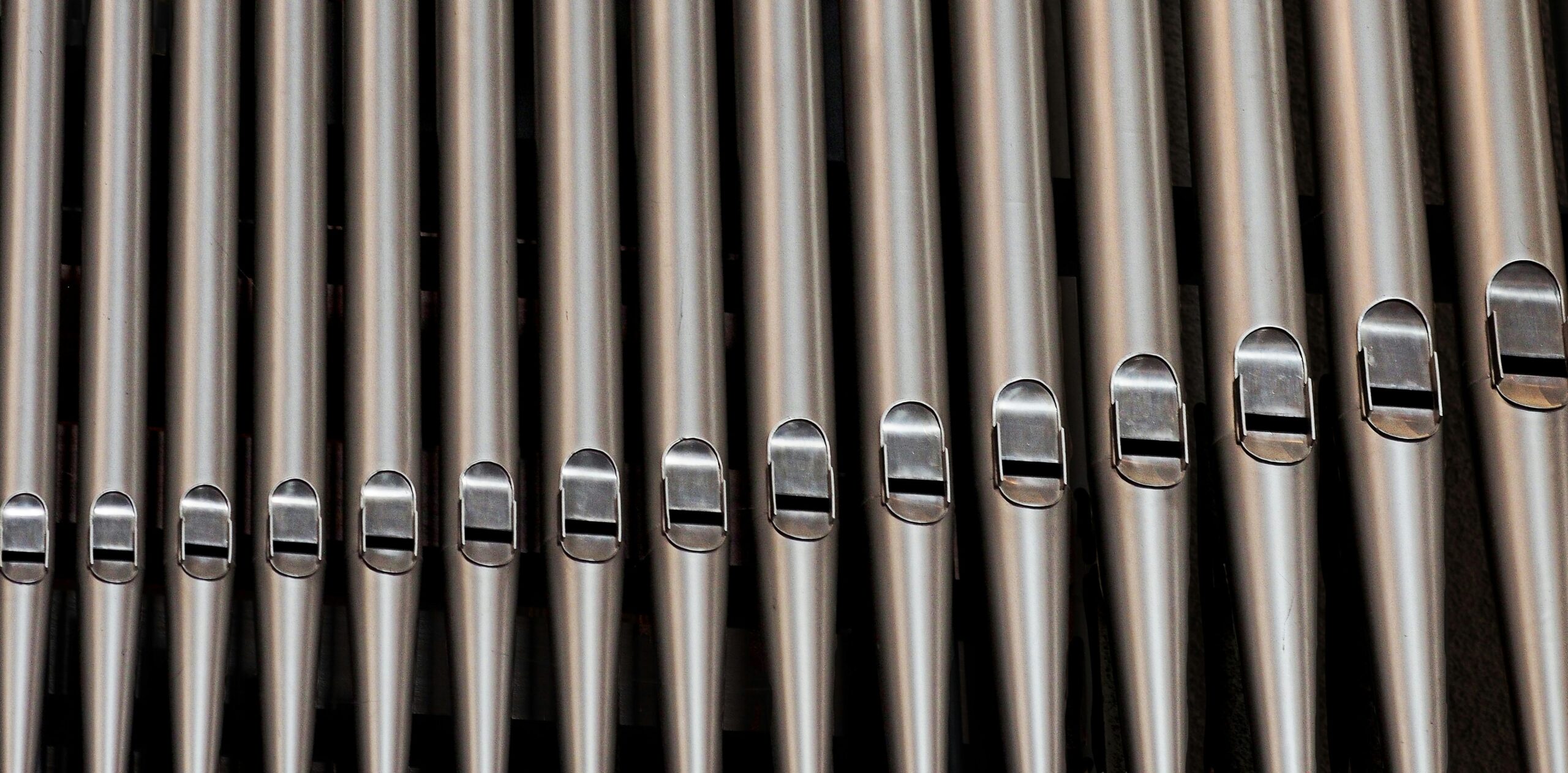Close-up of metallic organ pipes showcasing vintage design and harmony.